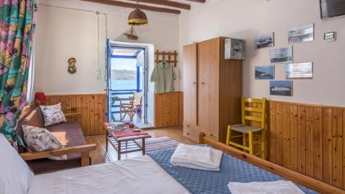 um quarto com uma cama e uma sala de estar em Blue Traditional Boathouse in Klima em Klima