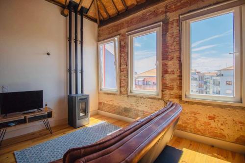 ポルトにあるStep In Porto Apartmentsのソファ、テレビ、窓が備わる客室です。