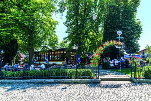 a garden with an arch and people in a park at Hotel & Restaurant Waldschloss in Passau