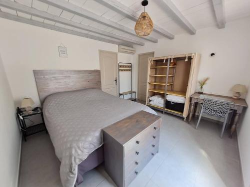 a bedroom with a large bed and a desk at appart cosy avec son exterieur chaleureux,piscine et parking prive in Fontvieille
