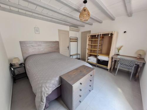 une chambre avec un grand lit et un bureau dans l'établissement appart cosy avec son exterieur chaleureux,piscine et parking prive, à Fontvieille