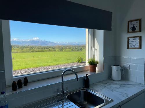 a kitchen sink and a window with a view of a field at Country Hideaway in Milltown