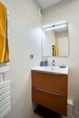 une salle de bain avec un lavabo et un miroir dans l'établissement L'esthète *100m de la mer*, à Larmor-Plage