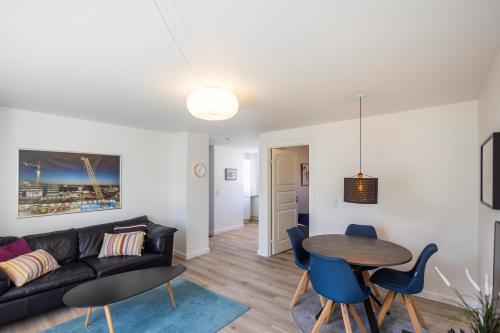 sala de estar con sofá negro y mesa en Central Lyngby Apartments, en Kongens Lyngby