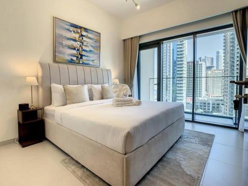 1 dormitorio con 1 cama grande y ventana grande en Key View - Burj Royale, en Dubái