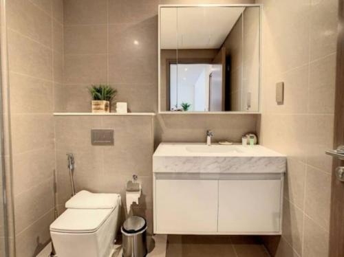 y baño con aseo, lavabo y espejo. en Key View - Burj Royale, en Dubái