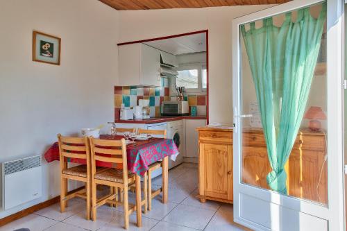 Il dispose d'une cuisine avec une table et deux chaises. dans l'établissement Maison pour 2 à 100 m de la plage de la Joie, à Penmarcʼh