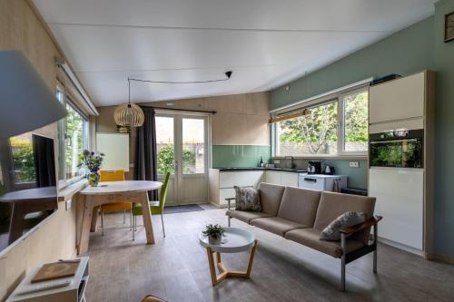 a living room and kitchen with a couch and a table at Vrijvakantiehuis Vrijburgstraat 10 in Vlissingen