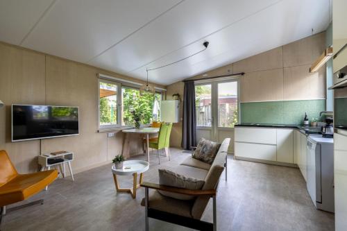 a kitchen and living room with a couch and a table at Vrijvakantiehuis Vrijburgstraat 10 in Vlissingen