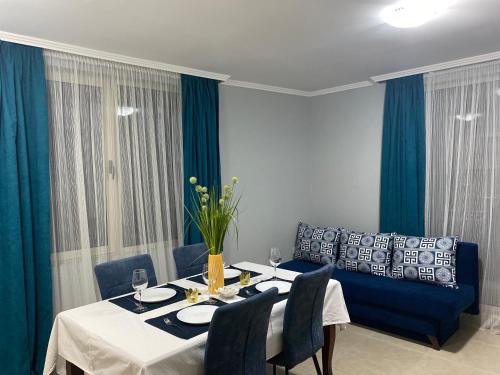 comedor con mesa y sofá azul en Hacienda Beach complex- Nicoleta apartment, en Sozopol
