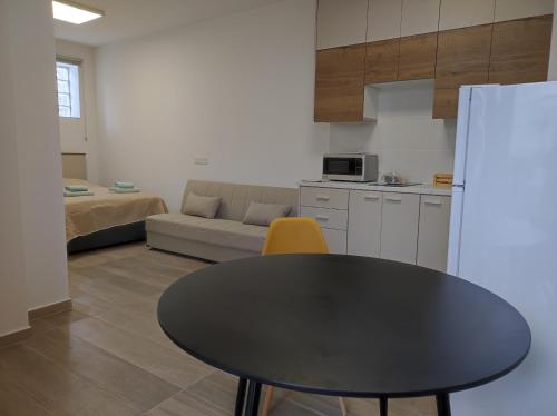 a kitchen with a black table and a yellow chair at St. Lazaros Studios 2 in Larnaka