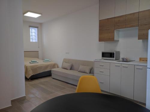 a kitchen with a couch and a bed in a room at St. Lazaros Studios 2 in Larnaka