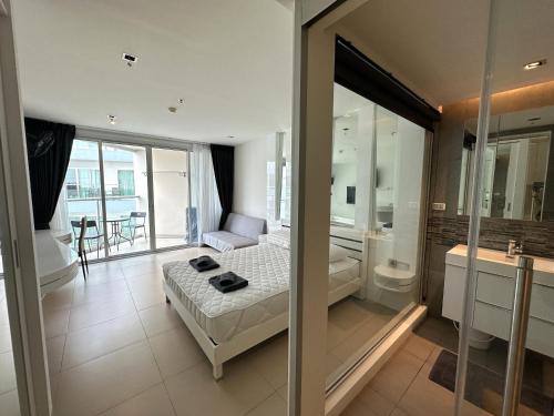 a bedroom with a bed and a glass wall at Sands Condo Pattaya 82 by ThaiminatorPattaya in Pattaya South