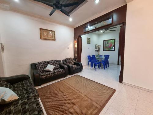 een woonkamer met een bank en een eetkamer bij HELLO HOMESTAY in Nibung Tebal