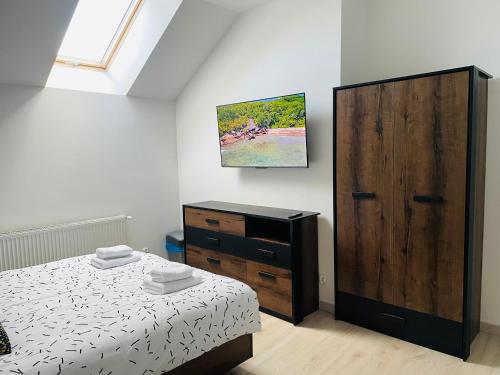 a bedroom with a bed and a wooden cabinet at Apartament Brzóza Królewska in Brzóza Królewska