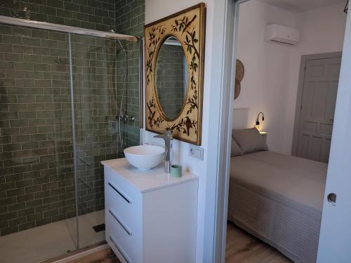 uma casa de banho com um lavatório e um chuveiro com um espelho. em Villa Delicia em Torrox