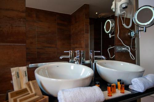 a bathroom with two white sinks and a mirror at Hotel Aires de l'Emporda in Vilacolum