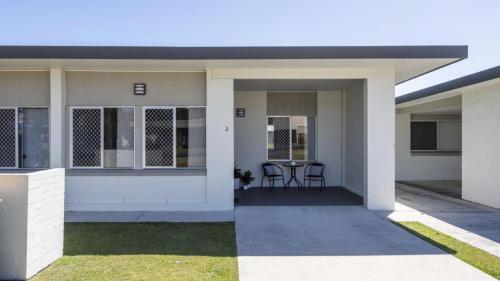 a house with a porch with two chairs in it at Sunnyvale 2 - Pet Friendly in Yamba