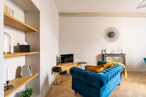 un salon avec un canapé bleu et une cheminée dans l'établissement Le Wilson Parc : T2 avec parking, à Dijon