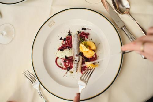 a person eating a plate of food on a table at Hotel Exel in Amstetten