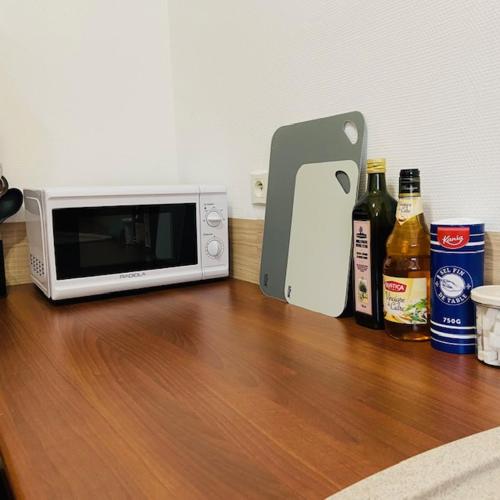 a microwave sitting on a wooden table with bottles of beer at FELTON - Appartement 2 pers Dinan in Dinan