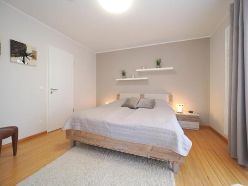 une chambre blanche avec un lit et une chaise dans l'établissement Kaiservillen Heringsdorf - Ferienwohnung mit 1 Schlafzimmer und Balkon D125, à Heringsdorf
