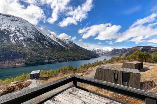 a house with a view of a river and mountains at Lem Cabins in Sogndal