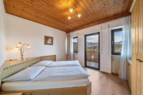 um quarto com uma cama e uma grande janela em Residence Kronstein - Fewo 9 em Tesimo