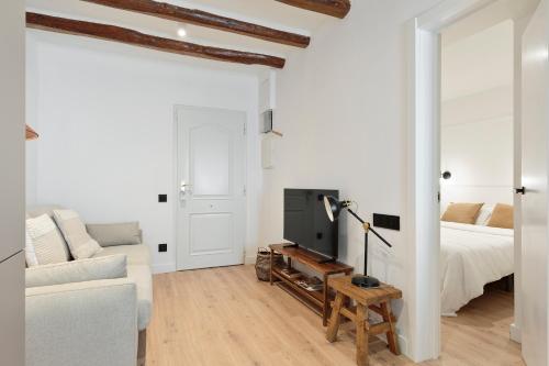 a white living room with a bed and a couch at Vibe Apartments by Olala Homes in Hospitalet de Llobregat