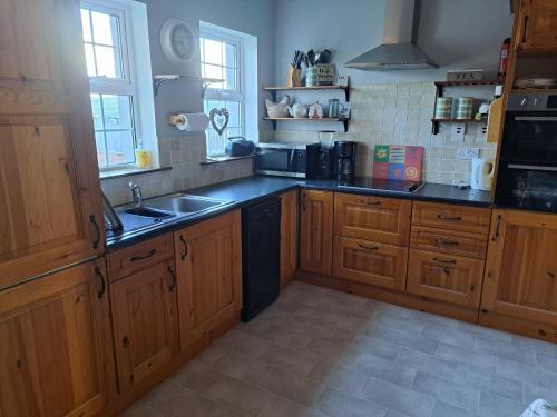 - une cuisine avec des placards en bois et un évier dans l'établissement Gormanstown House Apt, The Island, à Tullamore