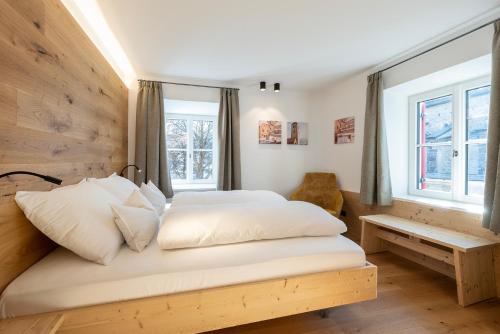 a bedroom with a bed with white sheets and a window at Residence Kugler in San Candido