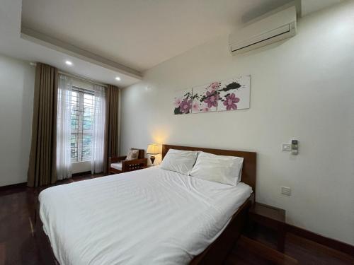 a bedroom with a white bed and a window at NINE HOUSING Truc Bach in Hanoi