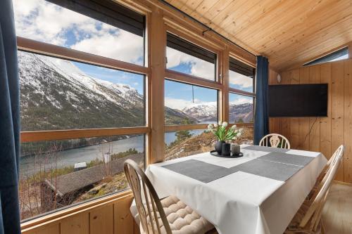 a dining room with a table and views of mountains at Lem Cabins in Sogndal
