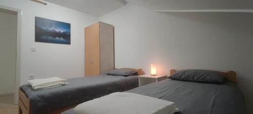 Un dormitorio con 2 camas y una vela. en Deniro Apartment, en Požega