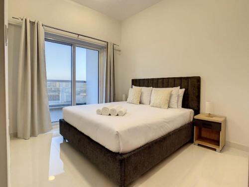 a bedroom with a large bed with a large window at Key View Hera Tower in Dubai