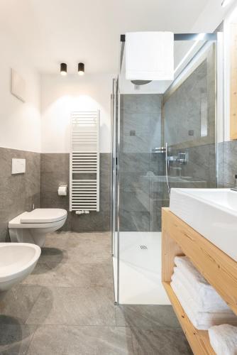 a bathroom with a shower and a toilet and a sink at Residence Kugler in San Candido