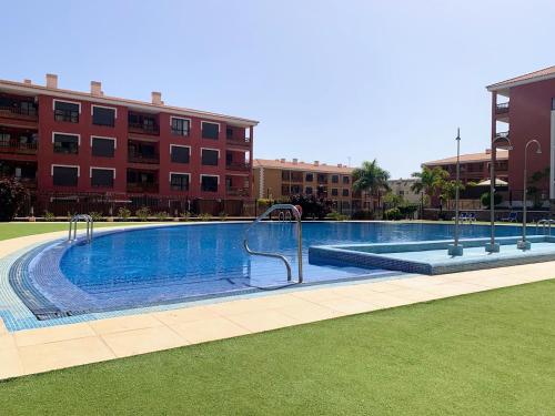 a large swimming pool in front of a building at Luminoso y Elegante, piscinas y pistas de pádel in Palm-mar