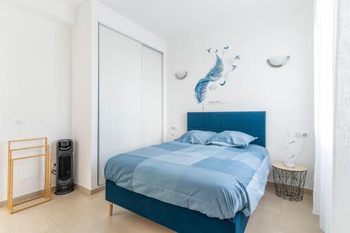 une chambre avec un lit bleu et une grande fenêtre dans l'établissement Le Grand Large - Appt proche plage Antibes, à Antibes