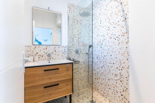 une salle de bain avec une douche avec un lavabo et un miroir dans l'établissement Le Grand Large - Appt proche plage Antibes, à Antibes