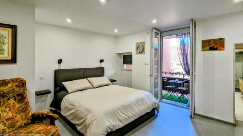 - une chambre avec un lit, une chaise et une fenêtre dans l'établissement Suite Fidji, à Luxeuil-les-Bains