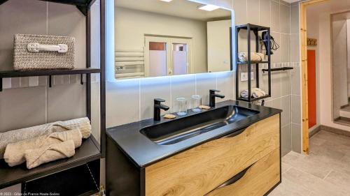 La salle de bains est pourvue d'un lavabo et d'un miroir. dans l'établissement Suite Fidji, à Luxeuil-les-Bains