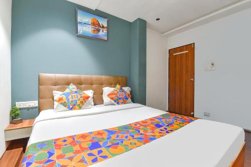 a bedroom with a large bed with a colorful comforter at FabHotel Nidhivan, Udhna Junction in Surat