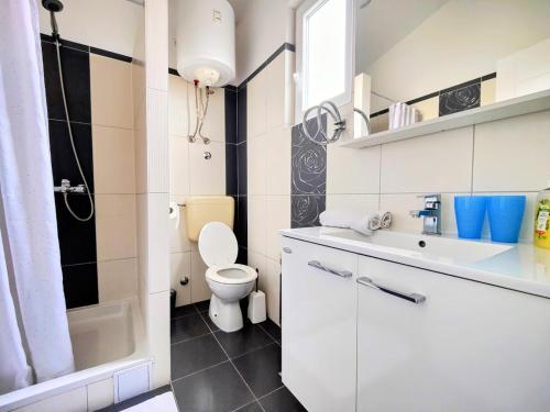 a white bathroom with a toilet and a sink at Apartments Dajana in Orebić