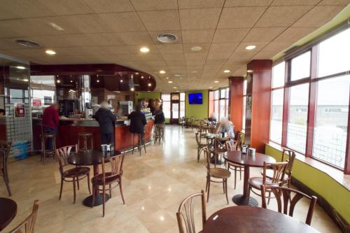 restauracja ze stołami i krzesłami oraz bar w obiekcie Hotel Torques w mieście A Coruña