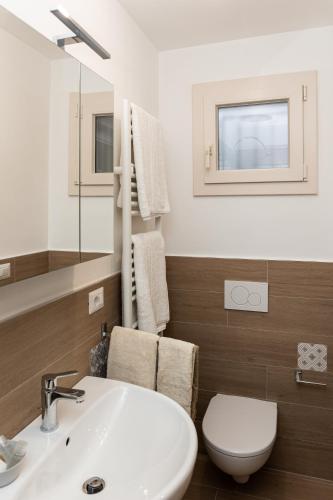 a bathroom with a sink and a toilet and a mirror at Peter & Dove's House in Mola di Bari