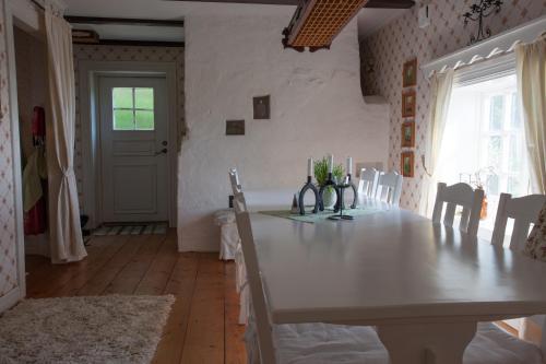 a dining room with a white table and chairs at Brunstorpsgård Bränneriet in Huskvarna