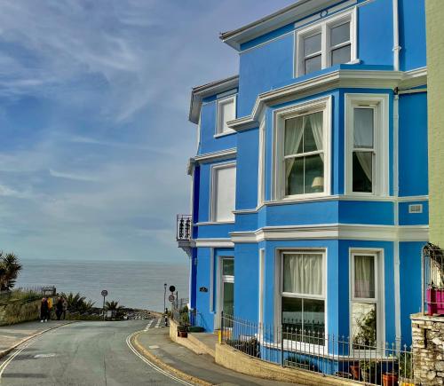 una casa azul al lado de una carretera en Top Deck - Fresh, stylish seaside apartment en Ventnor
