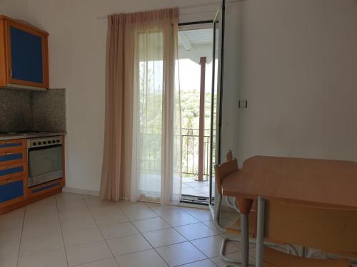 a kitchen with a table and a door to a balcony at Konstantina's House I in Koroni