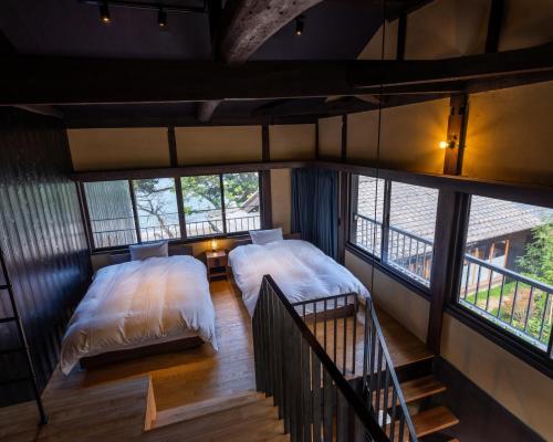 2 camas en una habitación pequeña con ventanas en sea-auberge shitsumi 海のオーベルジュ志積, en Obama