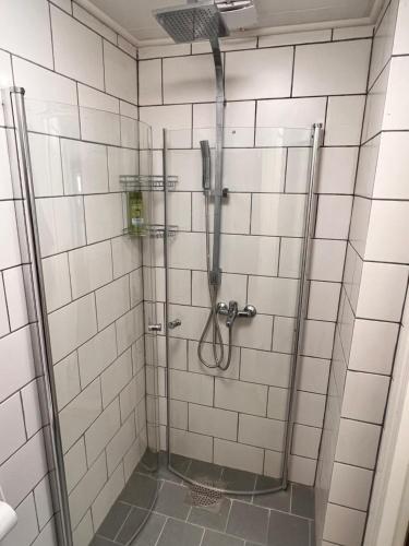 La salle de bains est pourvue d'une douche et de carrelage blanc. dans l'établissement HBA Appartsments, à Malmö